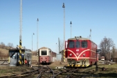 Motorová lokomotiva 705 913 u čerpací stanice, šrotovaný vůz Balm/ú 669 v pozadí